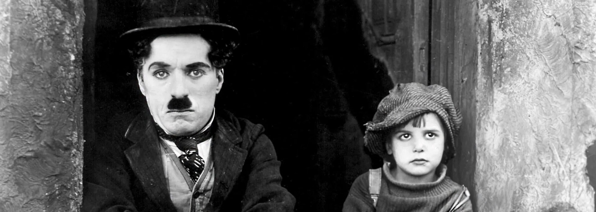 Escena de The Kid. Charles Chaplin y el niño en escalera.
